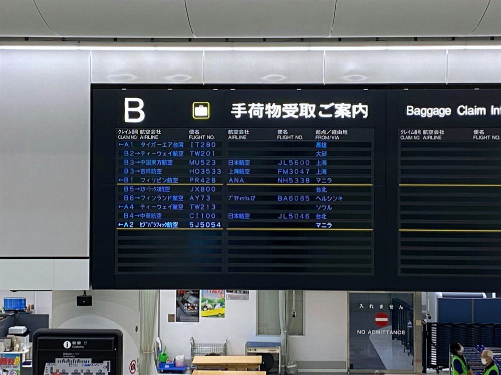 Japanese airport baggage claim board showing inbound flights